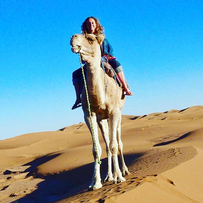 Jill Lena Ford nature inspired artist on a camel in the Sahara desert